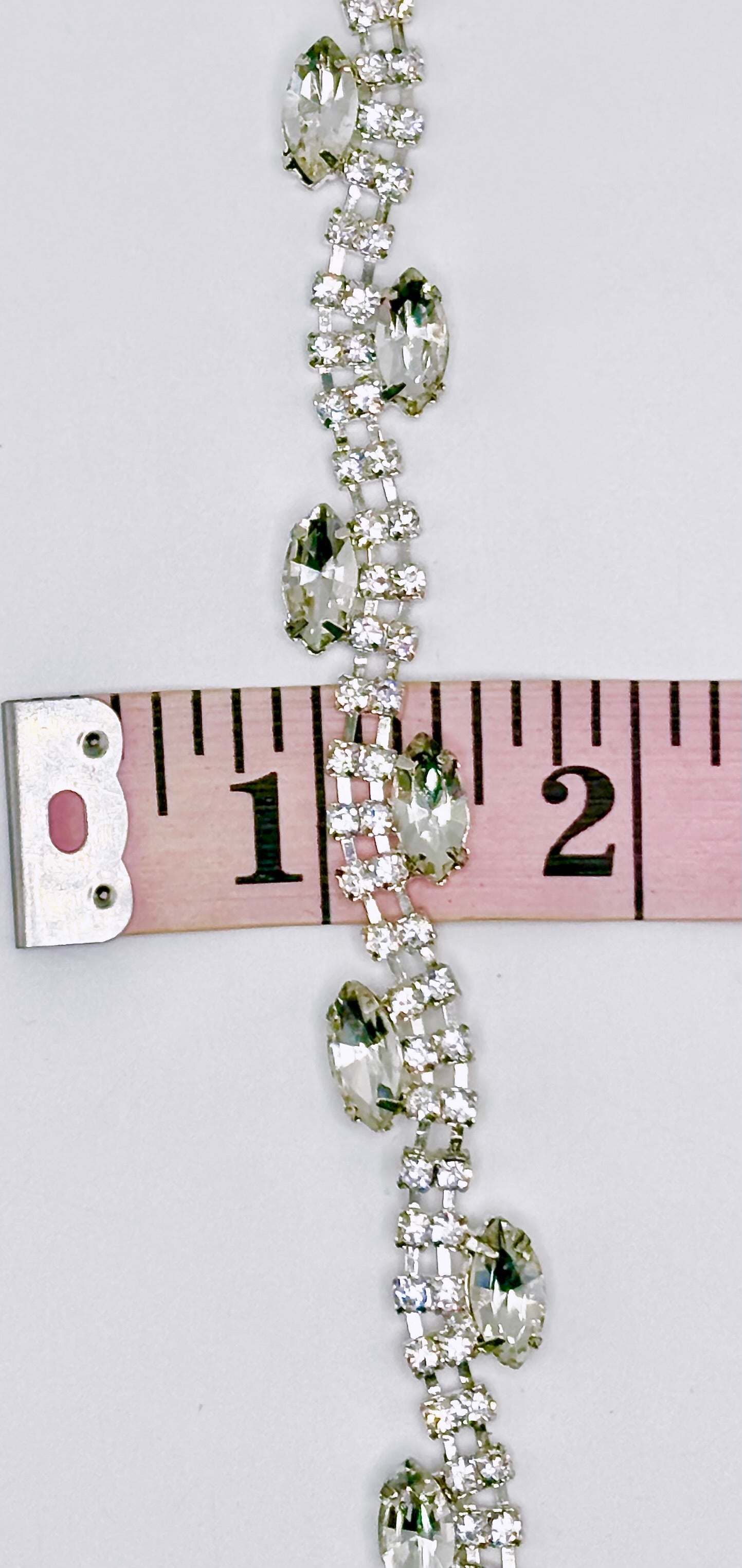 "Allison" Rhinestone Yardage with clear rhinestones on silver trim measuring approximately 3/8 inch wide.