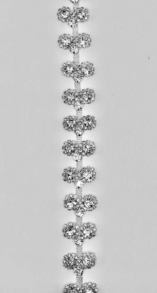 Clear rhinestones on silver chain back setting, approximately 3/4" wide.