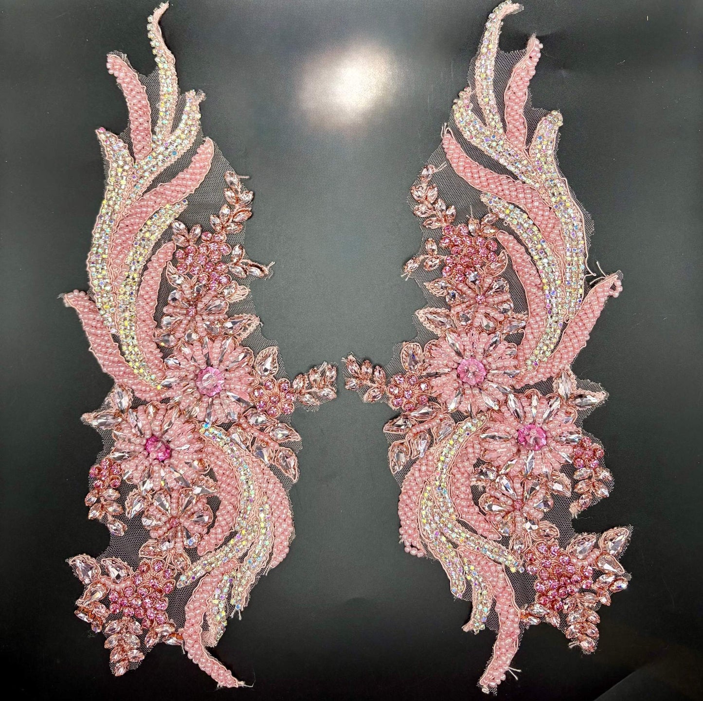 Handmade rhinestone and glass bead appliqué pair with pink floral design on a dark background.